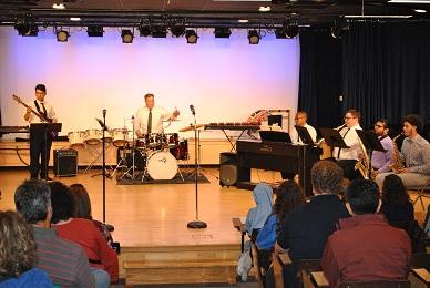 Instrumental band on Stage during performance and some of the front rows of the audience also in frame